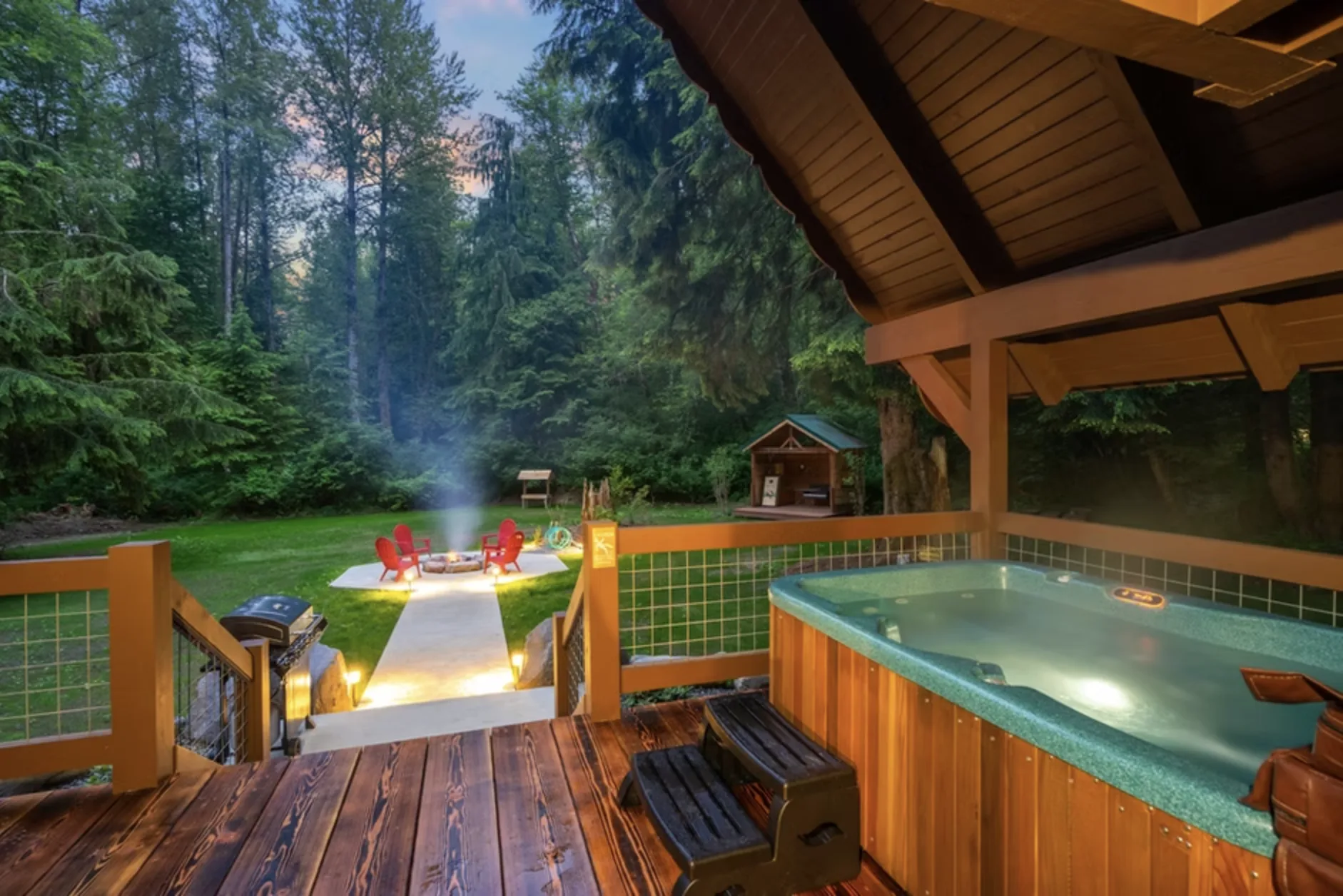 Fire pit lawn at Redtail Rendezvous under forest canopy